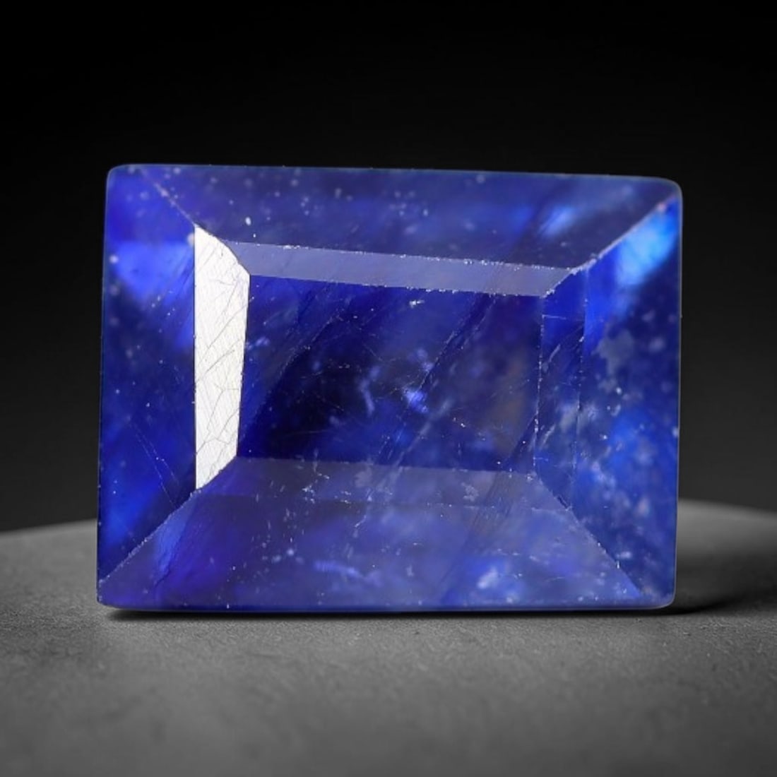 3.25 Carats Royal Blue Sapphire Emerald Cut Loose Gemstone, 9WJ: This sharp emerald rectangular faceted sapphire features an intense deep royal blue hue, brought to vivid life by crisp step-cut facets. Natural fine fissures and scattered tiny mineral micro-inclusio