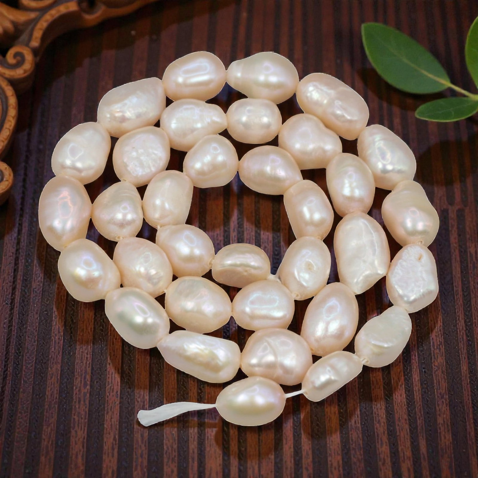 A Strand of Baroque Cultured Pearls, 20th Century, 80ZJ: Composed of baroque cultured pearls with a pale creamy-white body color and soft iridescent overtones, the strand is strung in a single continuous line. Each pearl exhibits an irregular, non-symmetric