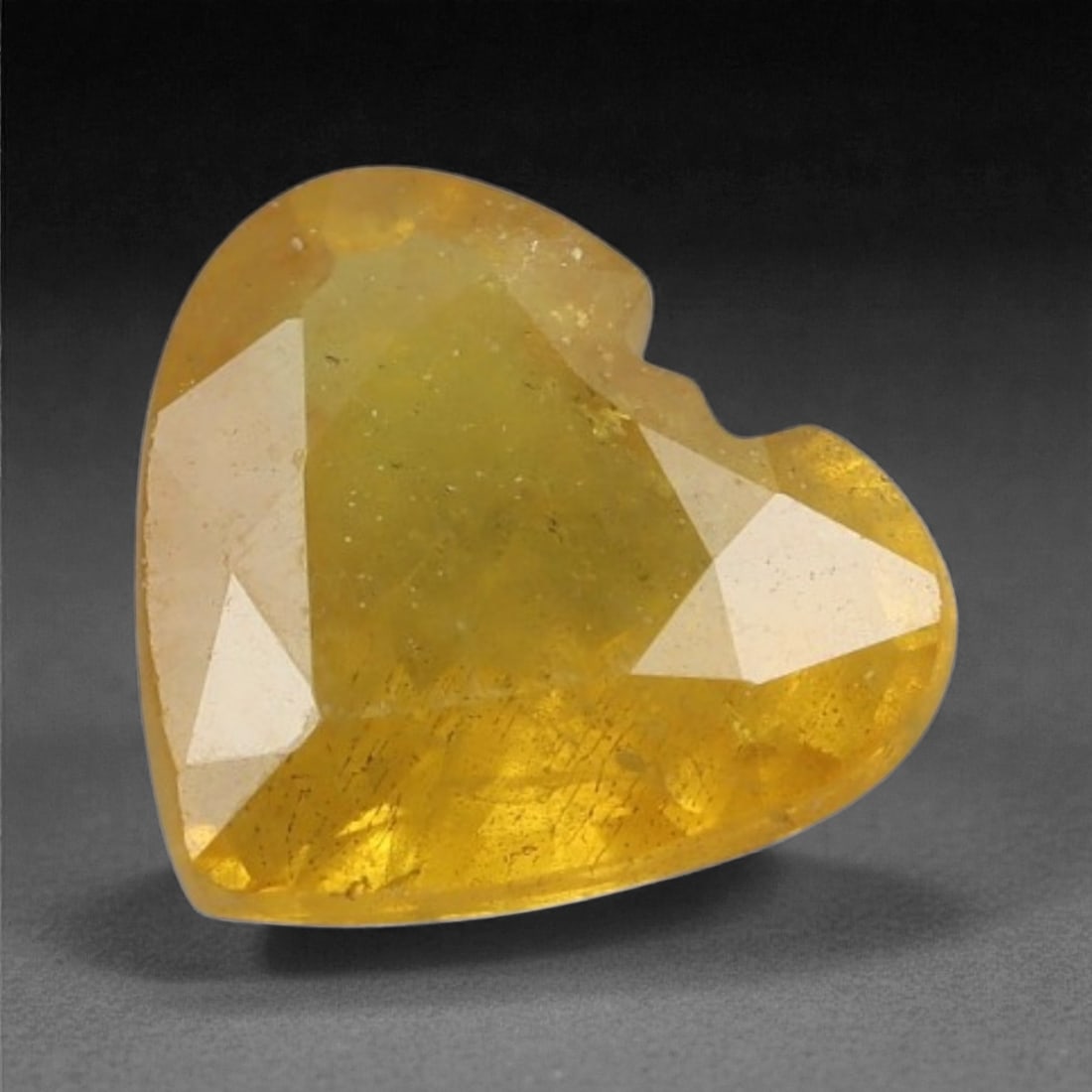 0.89 Carats Golden Yellow Sapphire - Natural Ceylon Stone , 35XK: This heart-shaped yellow sapphire glows with a warm, golden hue that exudes charm and timeless appeal. Soft internal reflections add gentle brilliance to its sunshine-toned body, while the unique shap