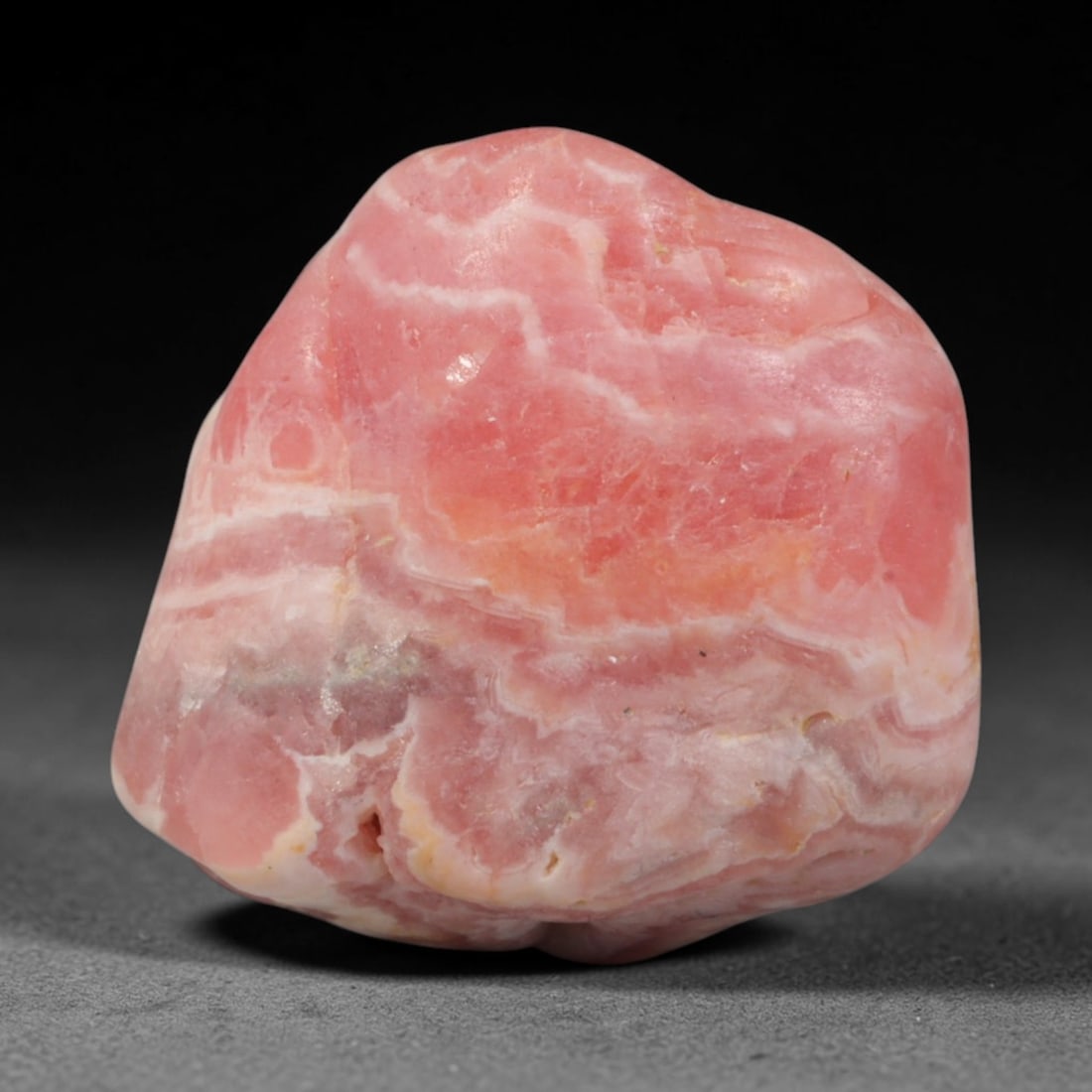 45ct Natural Argentine Rhodochrosite Tumbled Banded Rough Specimen, 98YQ: This smooth rounded rough specimen is natural banded rhodochrosite sourced from Argentina's Capillitas mining district, displaying characteristic layered concentric banding of soft blush pink, creamy 