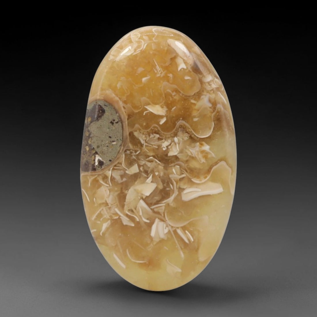 11.26 Carats Golden Madagascar Ammolite Cabochon Oval - Natural Stone, 19XC: This singular oval cabochon ammolite, measuring 22.4 x 13.3 x 4.1 mm, showcases a warm golden-yellow palette with intricate fossil shell patterns preserved within. The polished surface reveals delicat