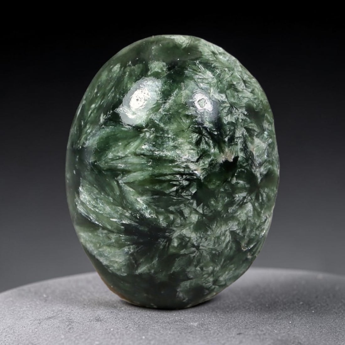 4.48 Carats Natural Deep Green Siberian Seraphinite Polished Cabochon, 95WW: This is a fully natural polished seraphinite specimen sourced from Siberian deposits, displaying distinct feathery fibrous inclusions that create beautiful flowing chatoyant patterns across its smooth