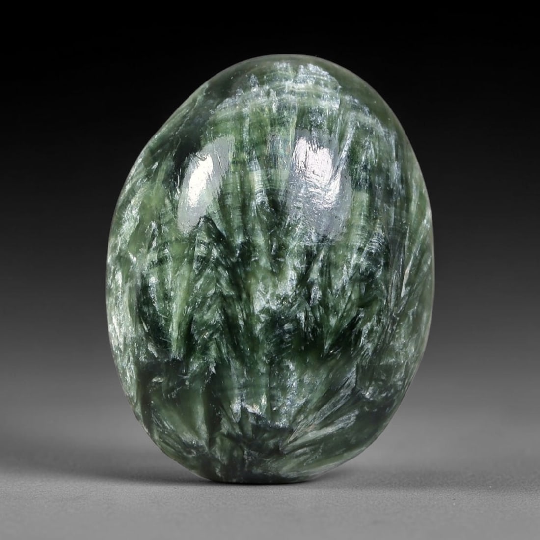 7.07 Carats Natural Deep Green Siberian Seraphinite Polished Cabochon, 96WW: This is a fully natural polished seraphinite specimen sourced from Siberian deposits, displaying distinct feathery fibrous inclusions that create beautiful flowing chatoyant patterns across its smooth