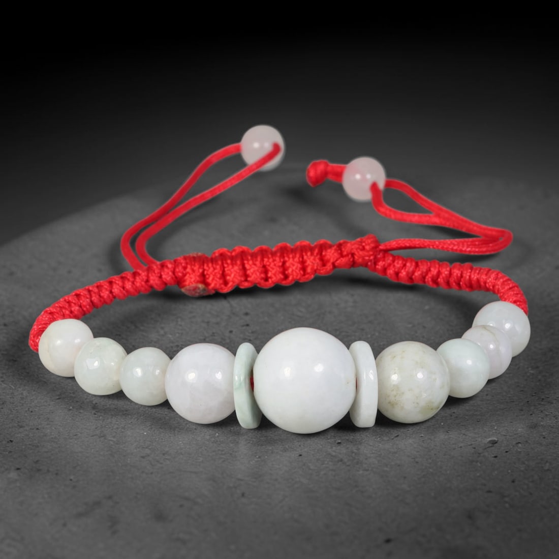 Natural Burmese Type A Milky White Round Jadeite Jade Adjustable Red Braided Bracelet, 62TA: Handcrafted from untreated natural Burmese Type A milky white jadeite, this woven red cord bracelet is centred around a substantial polished spherical jadeite bead measuring 13.93 millimetres, flanked