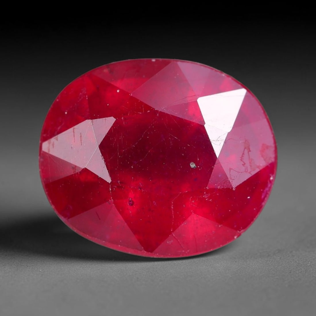 7.23 Carats Natural Madagascar Ruby Oval Faceted Loose Gemstone, 40XM: This sizable natural Madagascar ruby is cut into an oval brilliant faceted form, showcasing rich saturated crimson red hue characteristic of Malagasy corundum. Extensive natural internal silk veining,