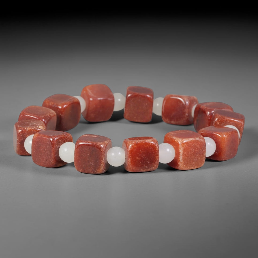 Natural Warm Red Square Cube Gemstone Beaded Bracelet, 24TA: Handmade bracelet crafted from smooth rounded square cube natural red stone beads, separated by milky white jadeite spacer beads for visual contrast. Each red cube features subtle natural mineral spec