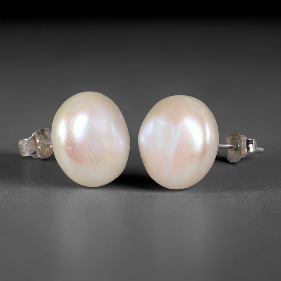 Natural Oval Freshwater Pearl Stud Earrings, 46WE: Classic minimalist stud earrings crafted with matched oval natural freshwater pearls, each measuring 12.6x5.8mm. The pearls feature smooth, thick nacre with soft creamy ivory base tones, accented by d