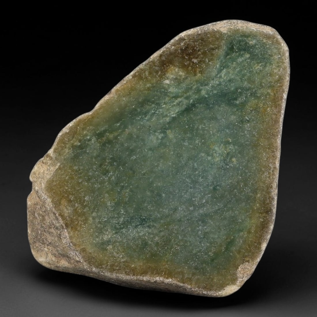 295ct Natural Type A Burmese Deep Teal Jadeite Jade Sliced Rough, 50YN: This specimen is a natural split rough stone of untreated Type A Burmese jadeite, retaining rugged natural weathered outer skin on its reverse side while the polished cut face displays semi-translucen