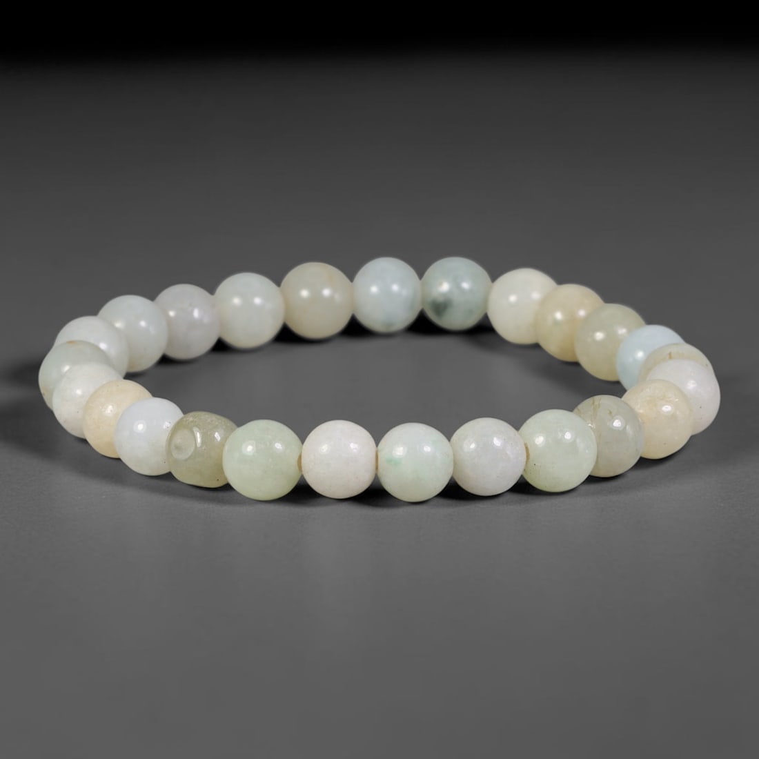 Natural Burmese Type A Pale Celadon & Cream Mixed Jadeite Jade Beaded Bracelet, 18TA: Crafted from untreated natural Burmese Type A jadeite jade beads with maximum bead dimension of 8.04mm, this single loop bracelet features smooth polished round beads blending soft celadon green, crea