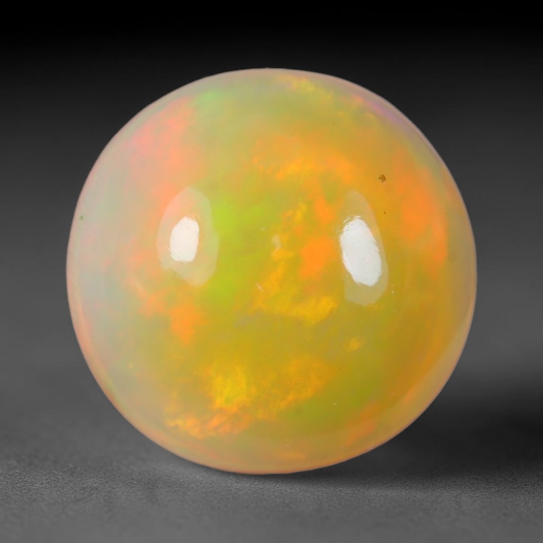 2.62 Carats Natural Ethiopian Welo Opal Oval Cabochon Loose Gemstone, 47XV: Natural Ethiopian Welo opal polished oval cabochon loose gemstone, luminous translucent milky white base stone with vivid multi-hued play-of-color featuring bright emerald green, lime yellow, soft blu