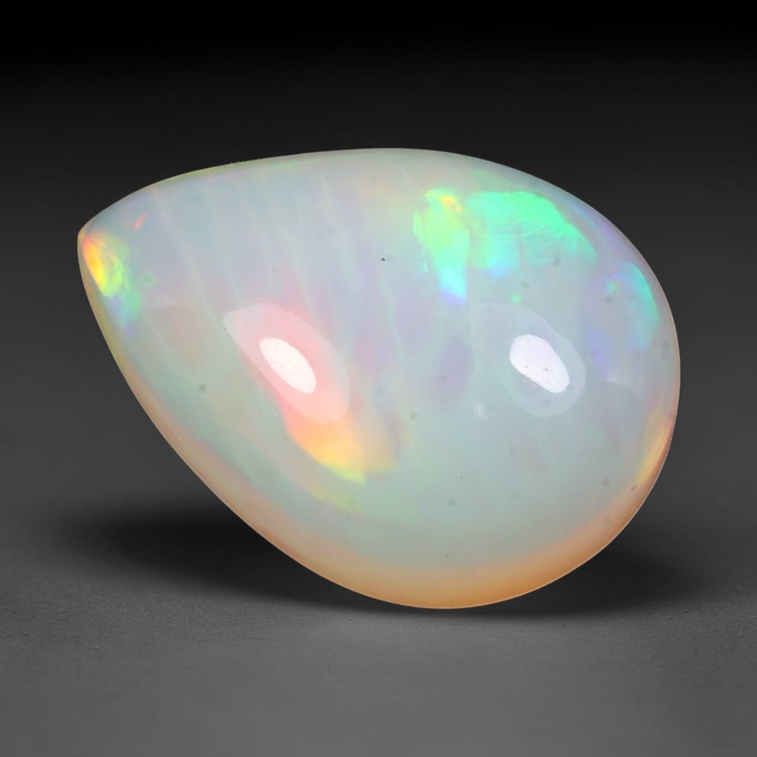 7.04ct Natural Ethiopian Welo Solid Opal Pear Cabochon Loose Gemstone, 11TG: Solid opal cabochon sourced from Ethiopia's Welo opal mining region, polished into a smooth pear teardrop domed form with high reflective surface gloss. The pale translucent milky base displays broad 