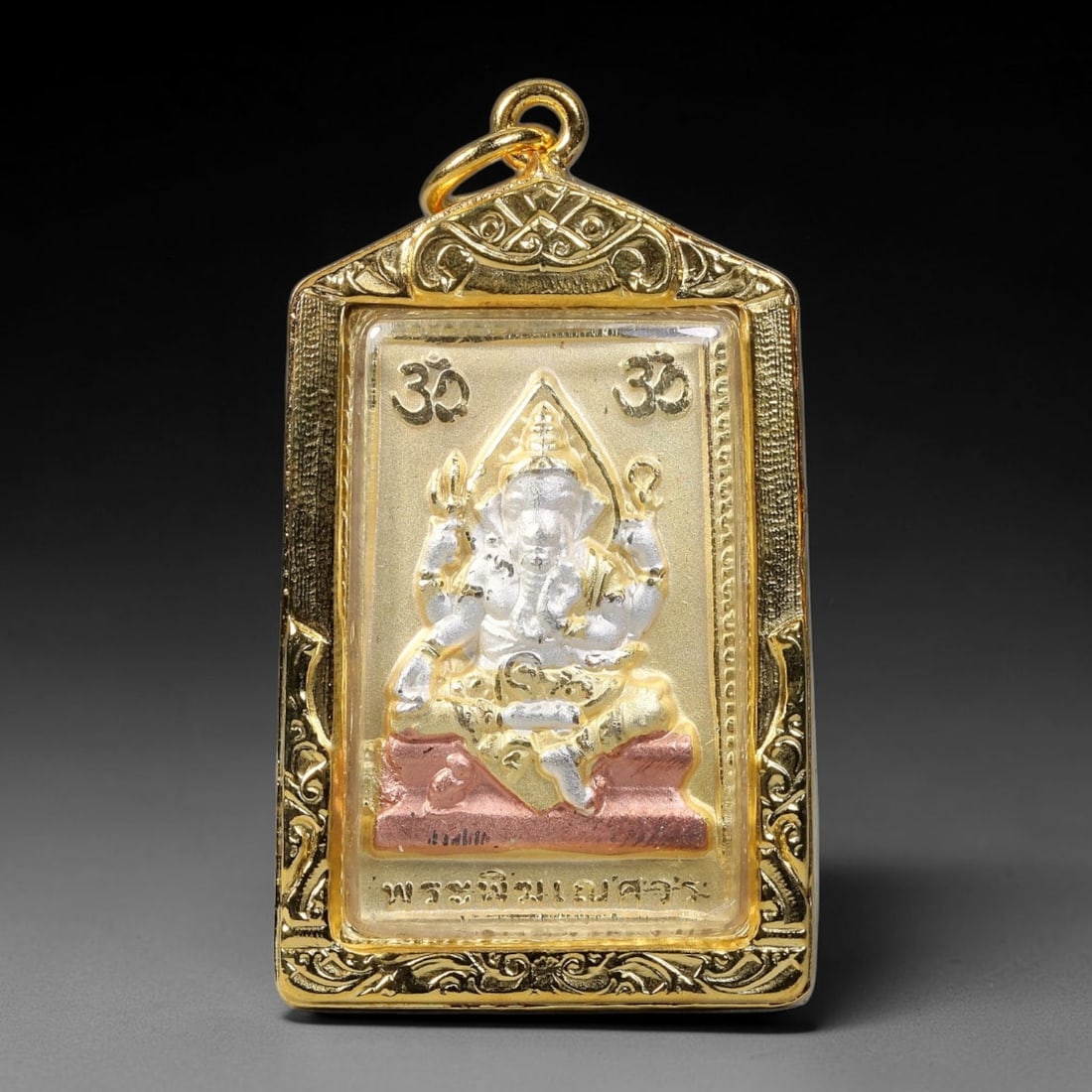 Thai Two-Sided Deity Votive Amulet - Gold Cased Pendant, 13YY: Hand-finished devotional tablet housed in ornately scroll-engraved polished gold casing with transparent protective covering and integrated hanging loop. One side features silver-toned four-armed Gane