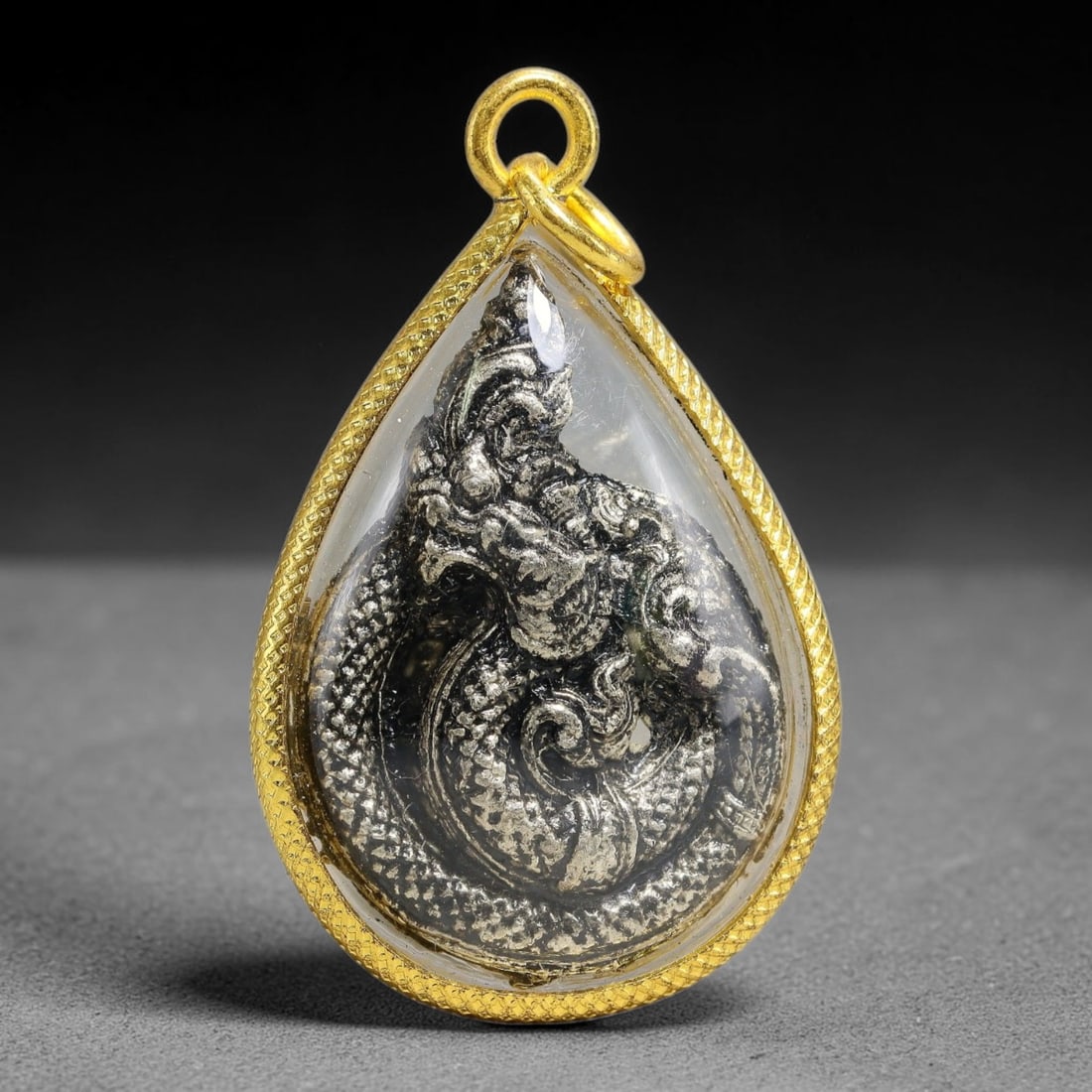 Thai Gold Frame Antique Naga Serpent Amulet Pendant With Clear Protective Casing, 68YY: Classic teardrop water-drop shaped gold plated amulet sized 4.0x2.0cm, fitted with double gold jump rings for necklace threading. Textured scale pattern gold outer frame encloses a sealed transparent 