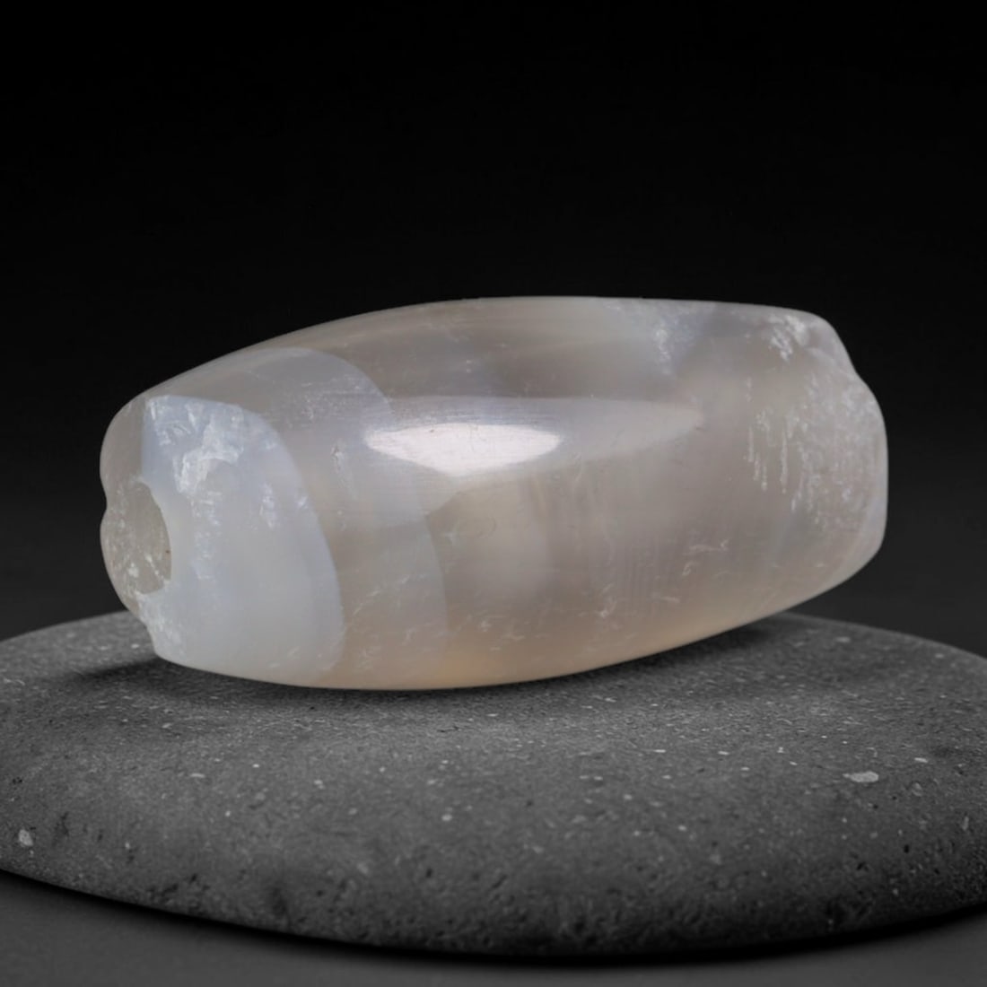 Ancient Greco-Bactrian Pale Translucent Chalcedony Slim Barrel Trade Bead (250 BCE - 125 BCE), 48XD: This delicate miniature barrel chalcedony bead was crafted by Greco-Bactrian Central Asian hardstone artisans, favored as minimalist light-weight talismans for layered ancient necklaces and long-dista