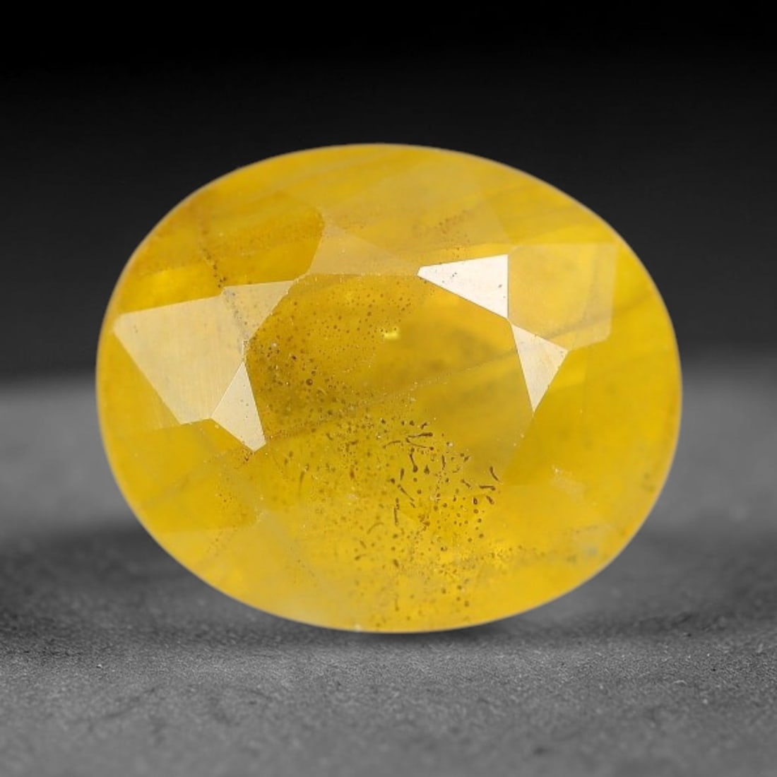 2.62 Carats Natural Yellow Sapphire Oval Faceted Loose Gemstone, 90XM: This natural yellow sapphire features a classic oval brilliant faceted cut, holding consistent warm golden-yellow color throughout the corundum crystal. Fine microscopic mineral specks and faint natur