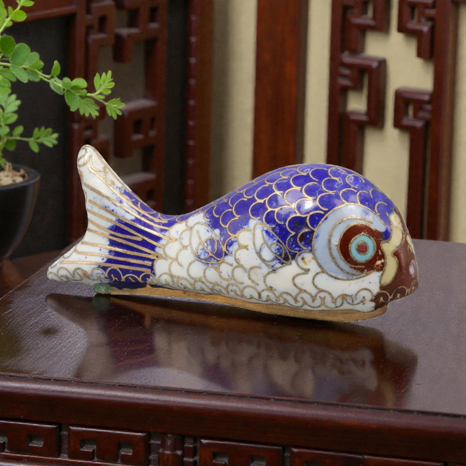 A Chinese Cloisonne Enamel Fish Effigy, 20th Century, 74YC: Constructed from a copper alloy body and decorated with cloisonne enamel, the object is formed as a stylized fish shown in profile with an elongated body and gently tapering tail. Fine metal wire cloi