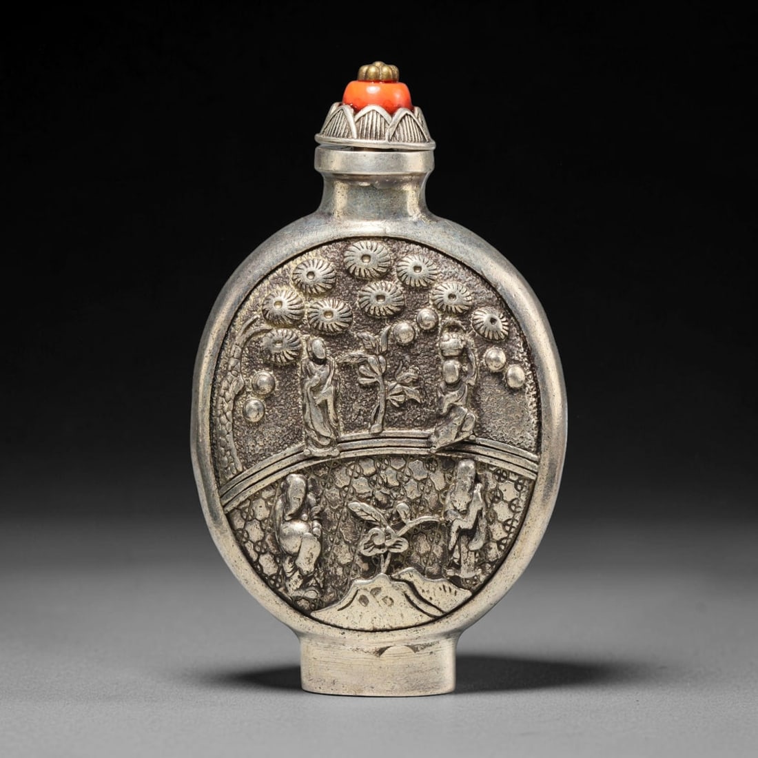 A Chinese Metal Figural Landscape Relief Snuff Bottle, 61WT: Crafted from base metal finished with a silvered exterior layer, the flattened oval body displays high relief detailing featuring four robed human figures distributed across a two-level landscape scen