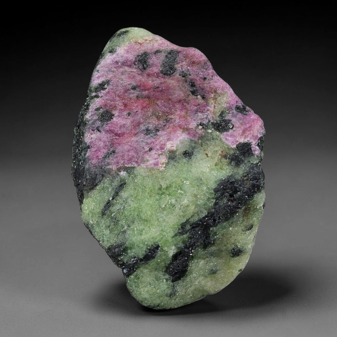 90ct Natural Tanzanian Ruby Zoisite Raw Rough Specimen Mineral Stone, 8YQ: This unpolished mineral rough is natural ruby zoisite sourced from Tanzania, exhibiting distinct banded mineral segregation of vibrant green zoisite, magenta ruby crystals, and dark hornblende inclusi
