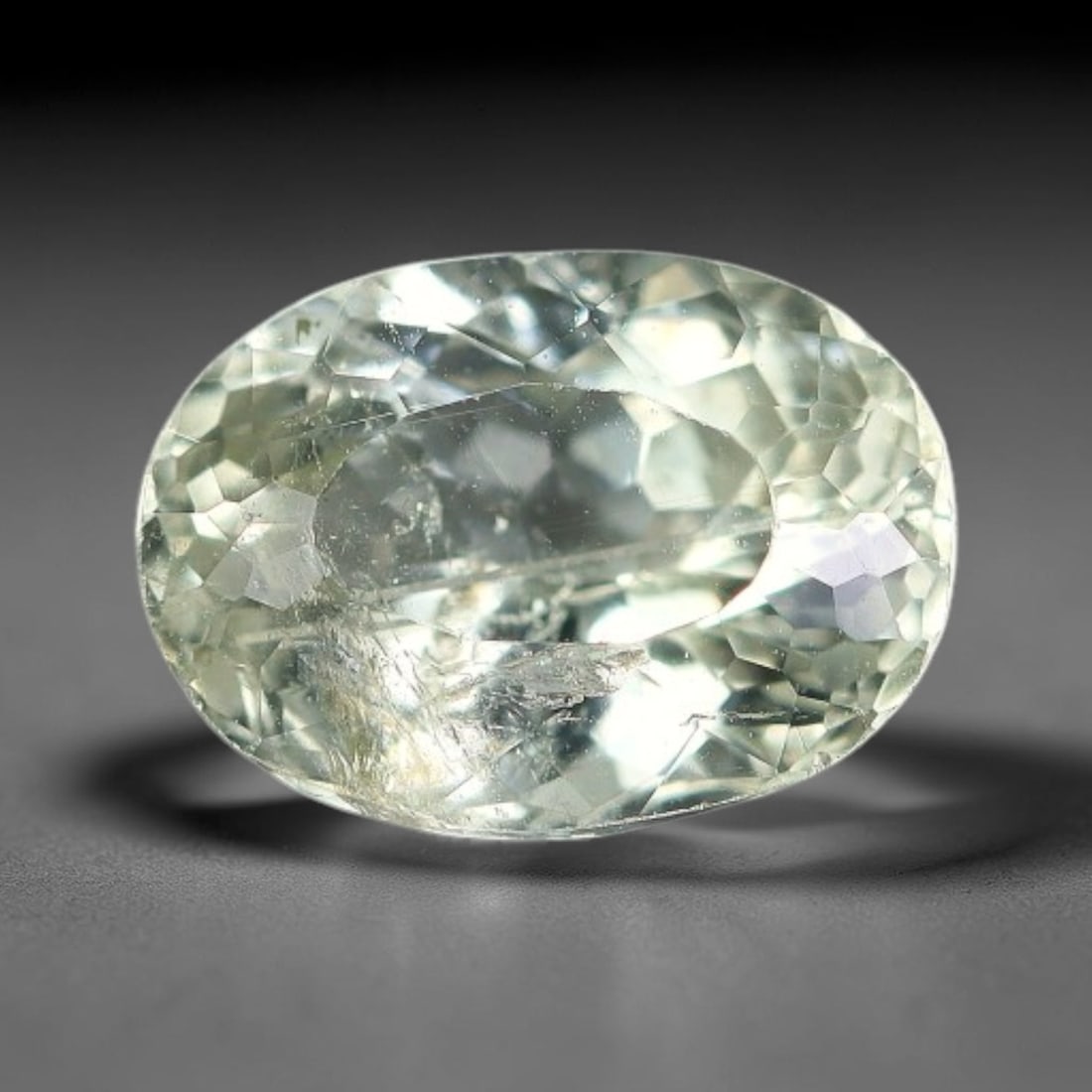 1.60 Carats Natural Pale Green Tourmaline Oval Faceted Loose Gemstone, 72XZ: This specimen is formed of natural tourmaline, processed with uniform faceting to enable full light passage through its crystalline interior. The stone carries soft pale green tonal saturation with mi