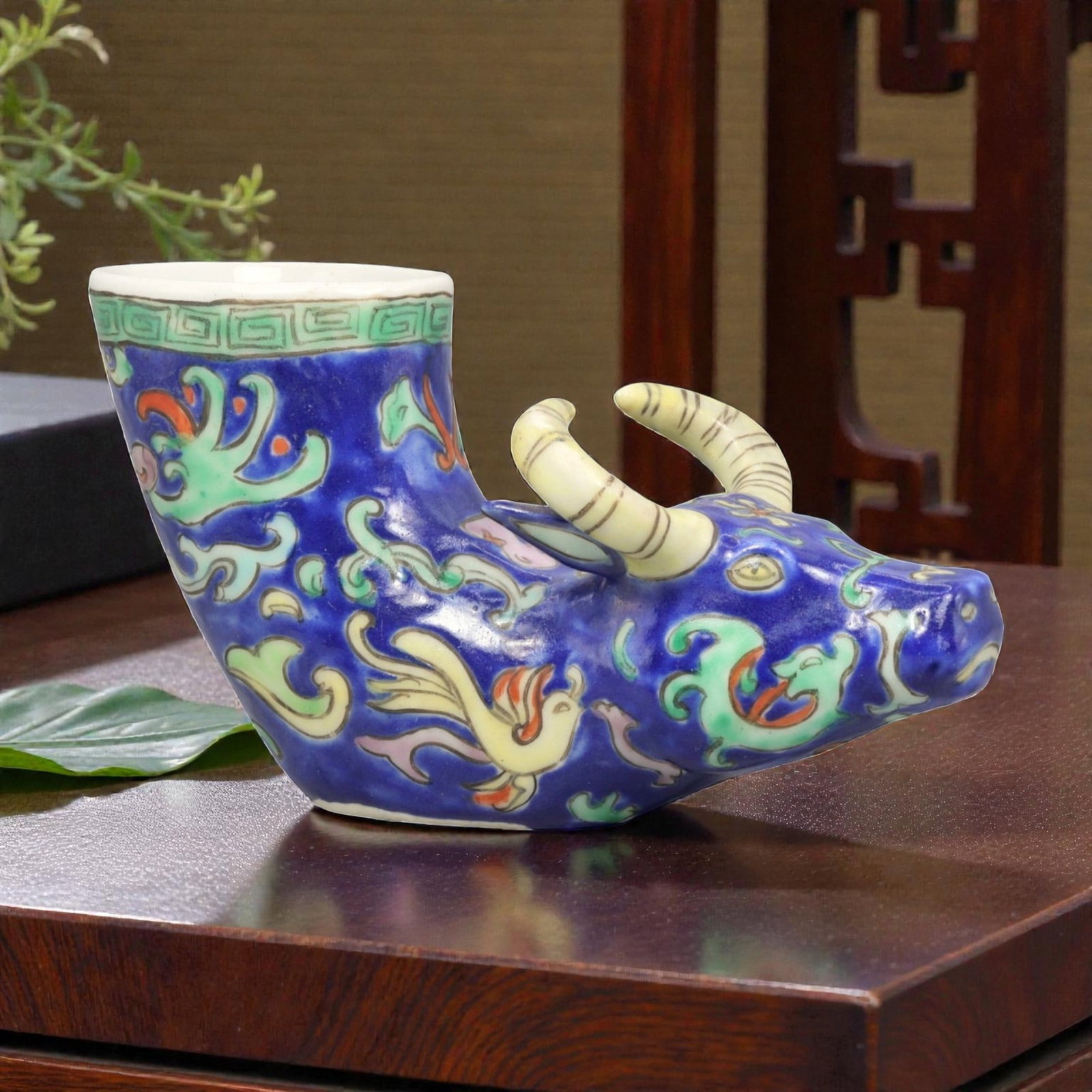 A Chinese Porcelain Bovine-Form Vessel, 20th Century, 85YC: Modeled in porcelain, the vessel is formed as a recumbent bovine with the head turned slightly to one side and the body hollowed to create an open container rising from the back. The animal is depicte