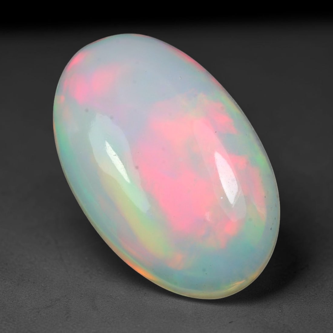 6.80ct Natural Ethiopian Welo Solid Opal Oval Cabochon Loose Gemstone, 16TG: Solid opal cabochon sourced from Ethiopia's Welo opal mining fields, polished into a sleek smooth oval domed shape with mirror-like surface gloss. The pale translucent milky base features large soft s