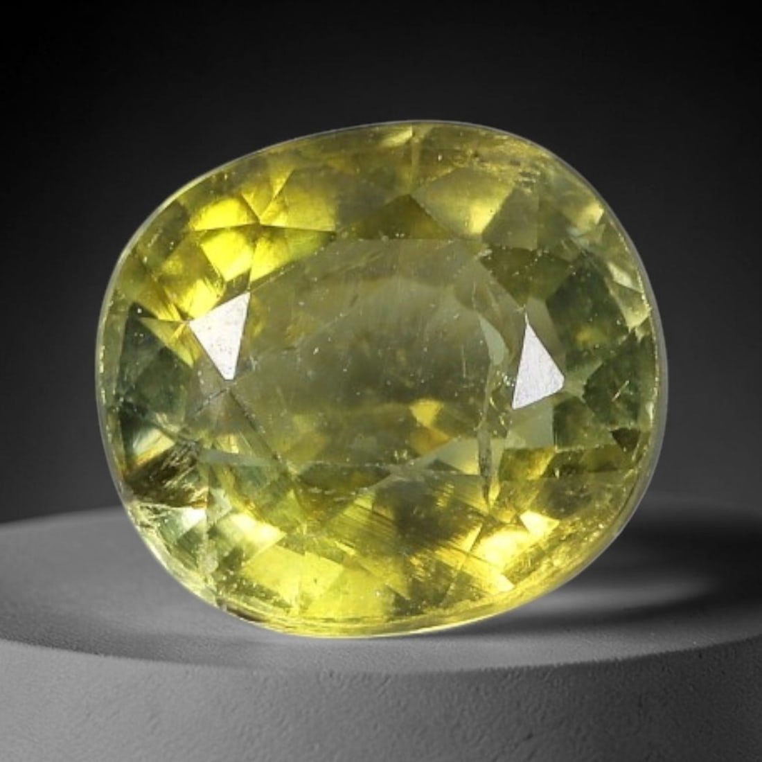 1.22 Carats Golden Olive Tourmaline Oval Cut - Natural Loose Gemstone, 66XC: This vibrant oval-cut tourmaline features a warm golden olive hue, evoking the glow of sunlight filtering through sunlit foliage. Its faceting creates a lively play of light, with subtle color shifts 