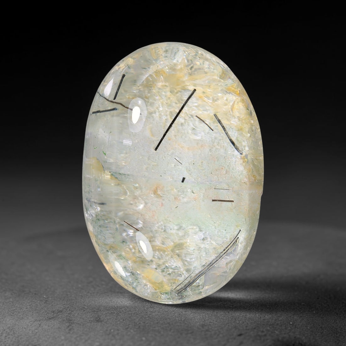 33.09ct Natural Brazilian Black Rutile Quartz Cabochon Loose Gemstone, 8YX: This polished cabochon of natural rutile quartz features countless distinct slender black rutile needle inclusions suspended within the clear quartz host crystal. The smooth domed surface enables full