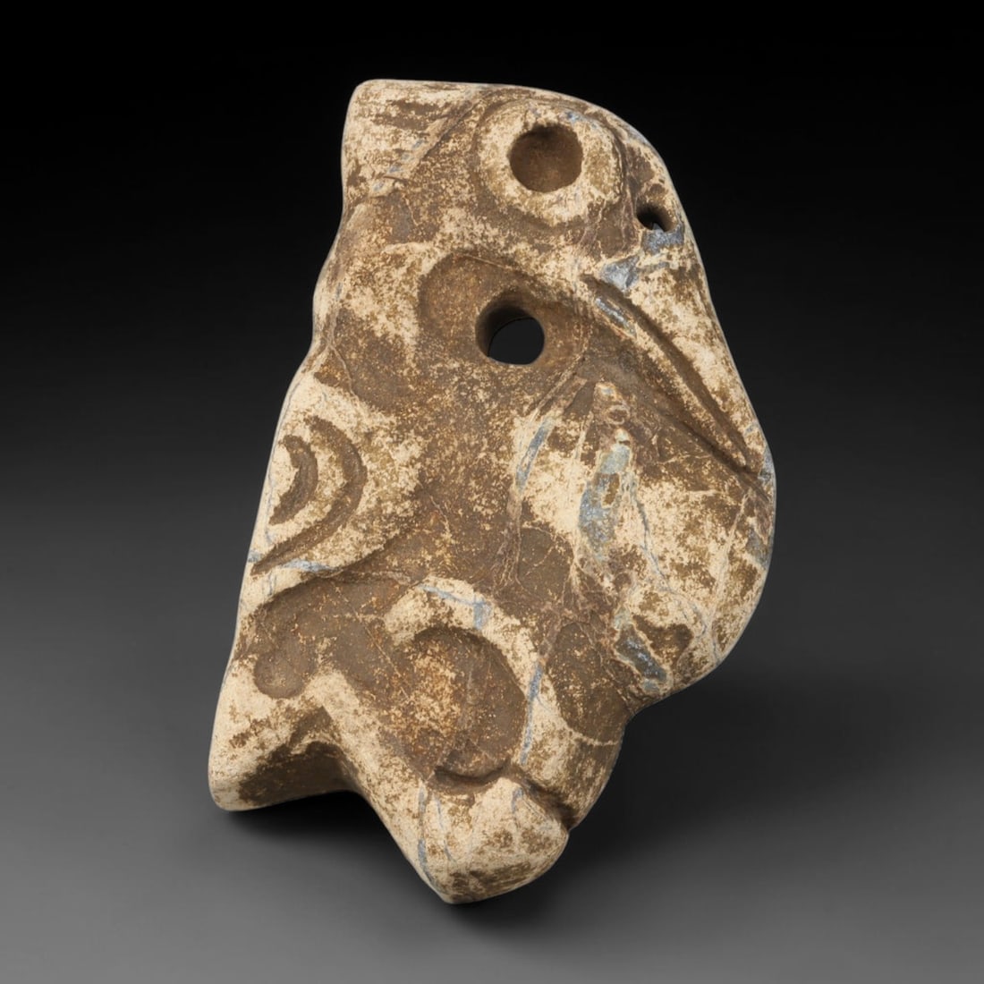 Ancient Medieval Near Eastern Tribal Stone Effigy, 93WT: Carved from natural variegated stone matrix bearing pale mineral veining, this abstract tribal effigy features deep hand-incised curvilinear motifs spread across its asymmetrical body form. Multiple d