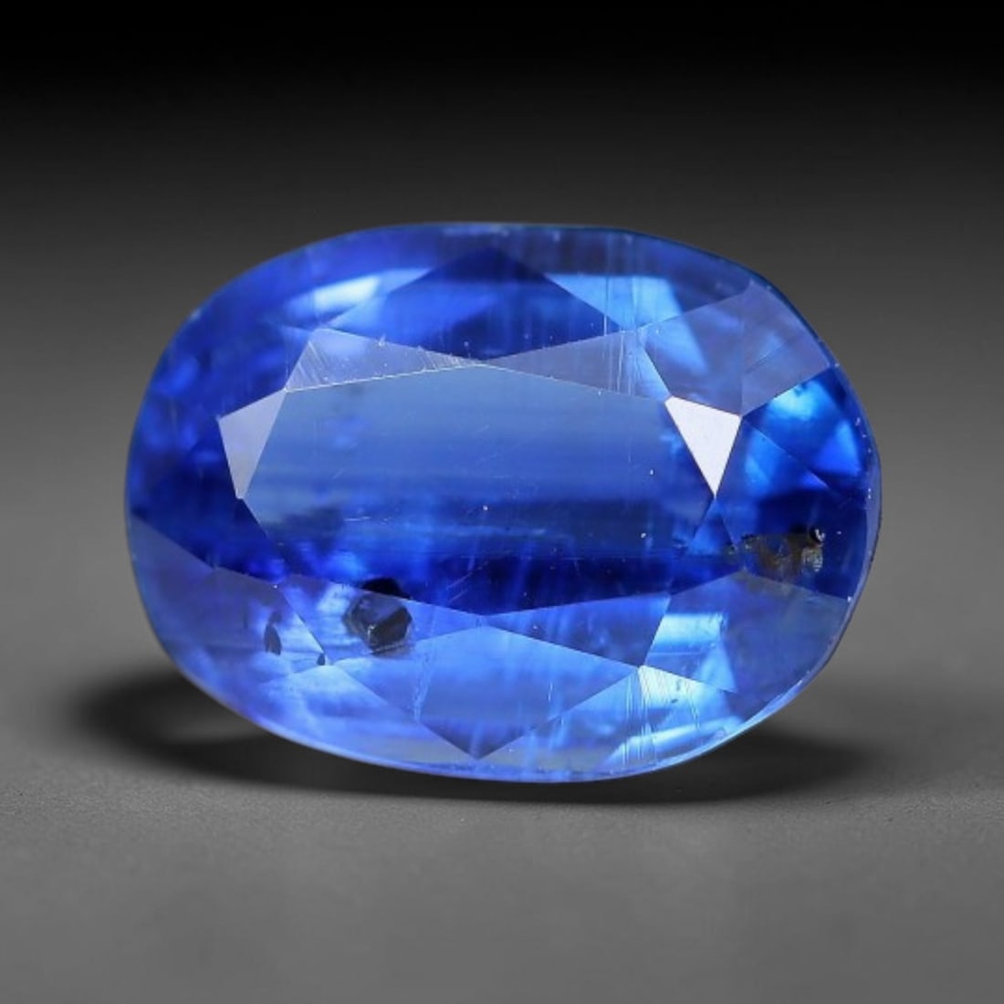 1.64 Carats Natural Brazilian Kyanite Oval Faceted Loose Gemstone, 58XY: This specimen consists of natural kyanite mineral material refined via professional faceted lapidary work, with uniform polished surfaces across the crystal exterior. Natural internal particulate mark