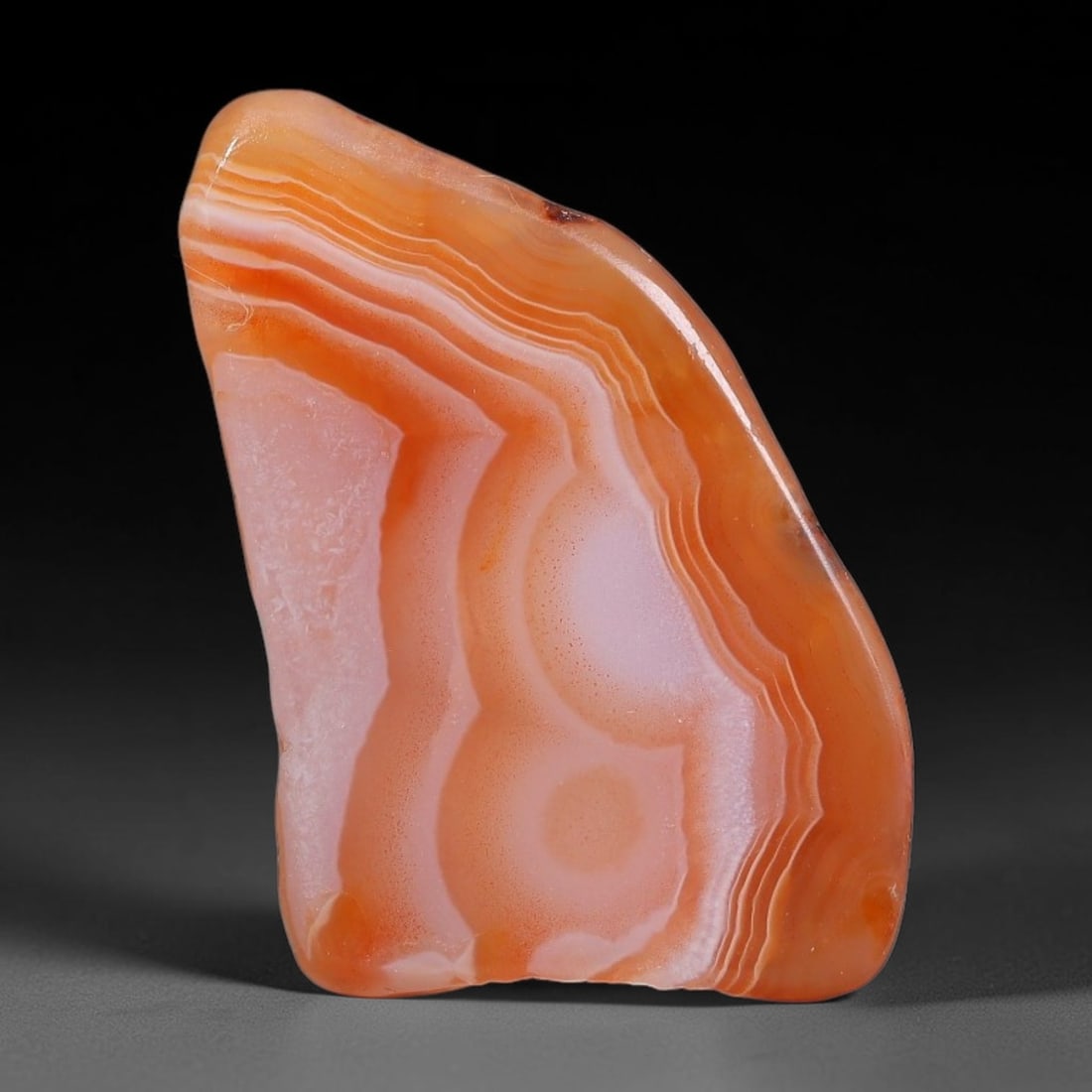 37ct Natural Brazilian Carnelian Banded Agate Sliced Rough Slab, 90YK: This polished slice specimen is natural carnelian banded agate sourced from Brazilian deposits, featuring concentric layered banding of rich orange, peach, and deep crimson-red chalcedony. One flat fa
