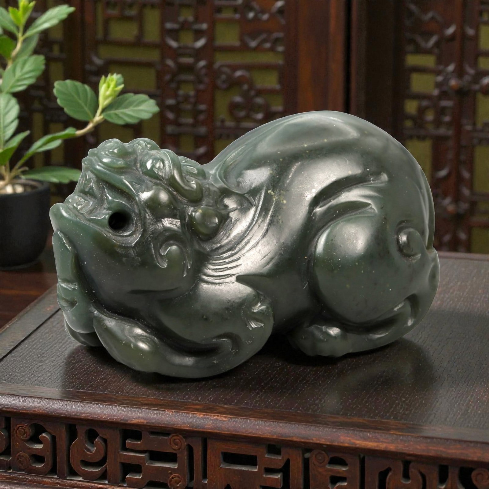 Chinese Jade Pixiu Beast - Carved Animal Figurine 4.6cm, 92ZC: Carved from deep green jade with soft translucency and scattered darker inclusions, this small sculptural figure depicts a pixiu rendered in a compact recumbent posture. The carving is worked fully in