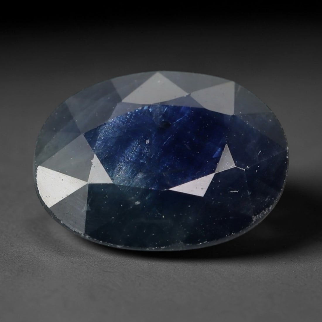 2.32ct Natural Madagascar Dark Blue Sapphire Oval Loose Faceted Gemstone, LZ293: This natural oval faceted sapphire from Madagascar weighs 2.32 carats with exact dimensions of 9.6x7.4x3.5mm. It carries a deep, rich navy royal blue core tone, transitioning to translucent cool grey-