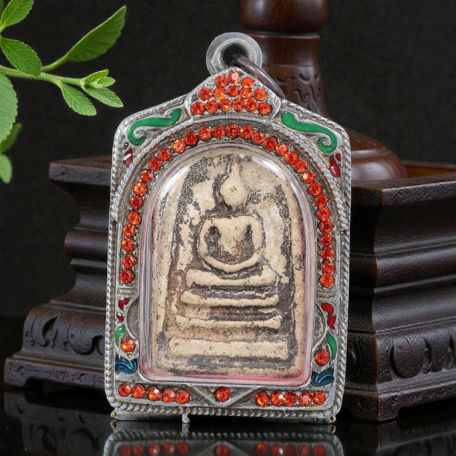 Thai Phra Somdej Amulet - Red Crystal Enamel Silver Tone Pendant, 64ZB: A Thai Buddhist Phra Somdej amulet featuring a seated Buddha figure on tiered bases, housed in a silver-tone metal casing with red crystal and enamel detailing. The glass-fronted enclosure protects th