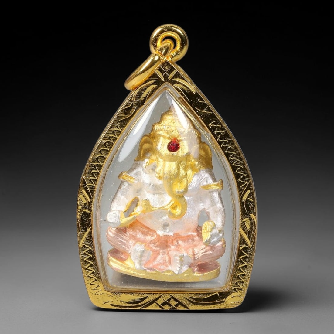 Thai Tri-Tone Ganesha 3D Votive Amulet - Gold Cased Pendant, 20YY: Small pointed teardrop shaped devotional pendant wrapped in finely engraved polished gold casing with transparent protective cover and integrated bail loop. The front displays a three-dimensional seat