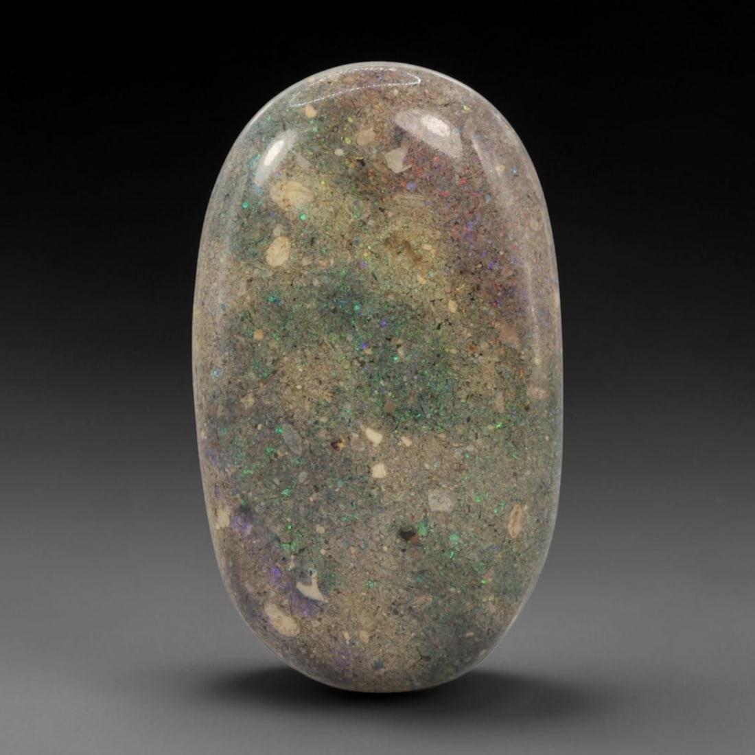 23.07 Carats Australian Matrix Opal Oval Cabochon - Natural Stone, 73XB: This singular oval cabochon matrix opal, measuring 34.2 x 20.1 x 4.9 mm, showcases a warm, earthy host matrix dotted with shimmering opal flecks. The polished surface reveals a soft, diffused play of 