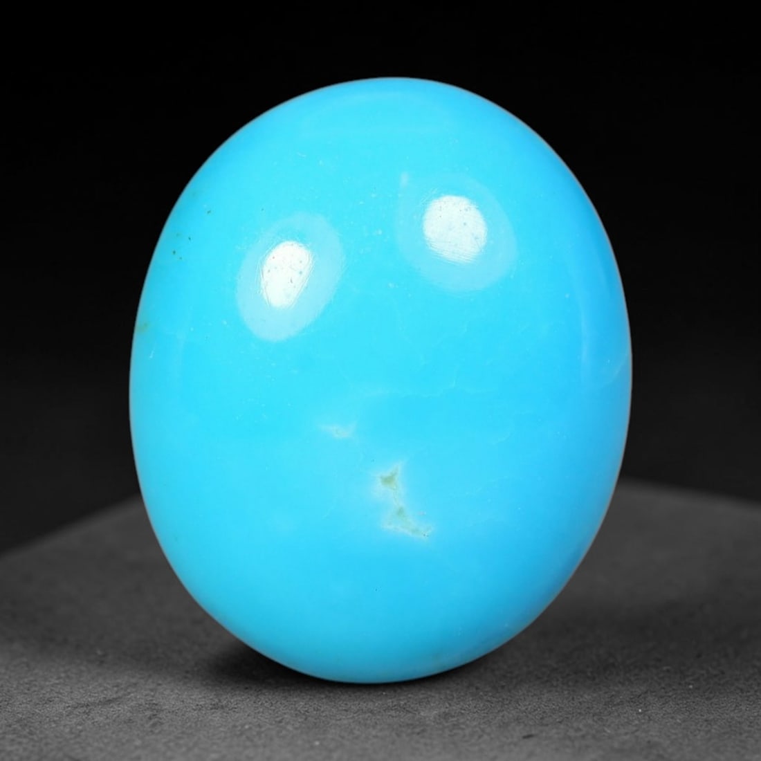 4.31ct Natural Sleeping Beauty Turquoise Oval Cabochon, 90WW: Hand polished Sleeping Beauty turquoise cabochon featuring striking saturated sky-blue body tone with subtle natural mineral flecks visible across the smooth surface. The stone boasts a sleek high-glo