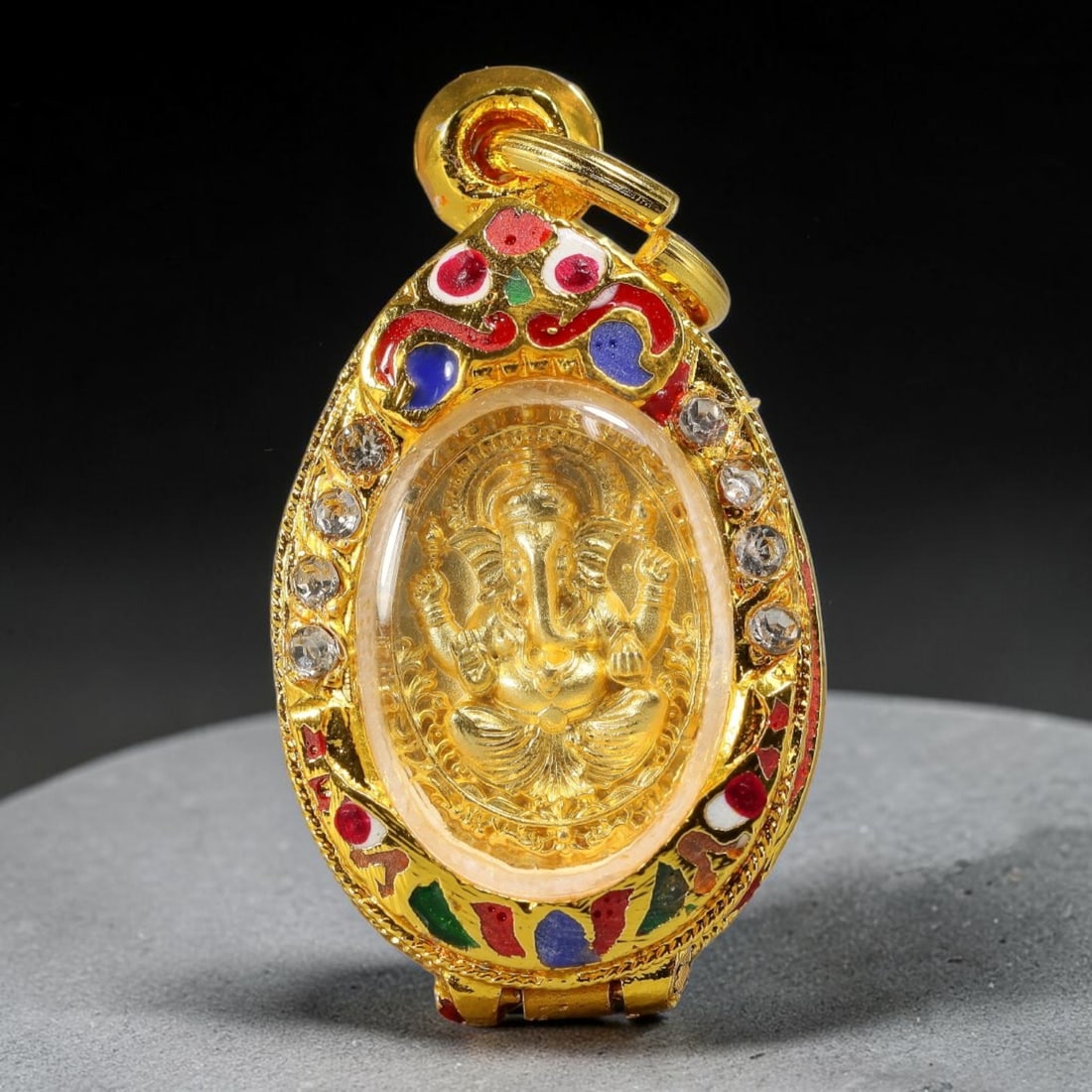 Thai Enamel Crystal Ganesha Locket Votive Amulet - Gold Cased Pendant, 19YY: Small hinged oval locket-style devotional pendant crafted with polished gold metal, vibrant multi-color cloisonne enamel in red, blue, green and white, plus clear round crystal stone inlay along the f