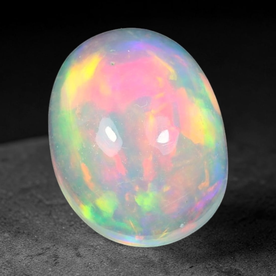 1.38ct Natural Ethiopian Welo Solid Opal Oval Cabochon Loose Gemstone, 38TG: Solid opal cabochon mined from Ethiopia's Welo opal deposits, polished into a smooth elongated oval dome with high reflective gloss. The translucent pale milky base hosts broad shifting play-of-color 