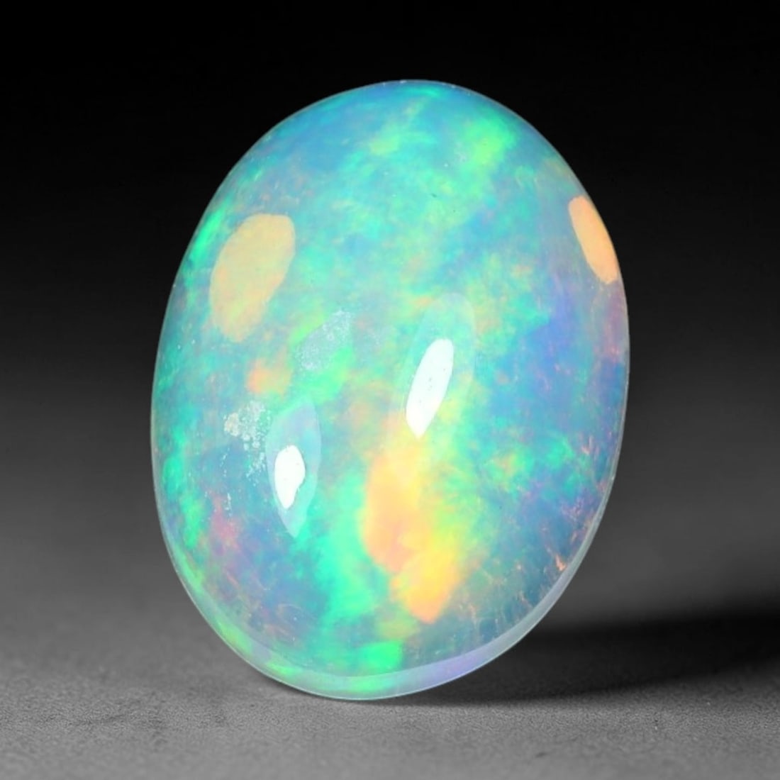 1.55ct Natural Ethiopian Welo Solid Opal Oval Cabochon Loose Gemstone, 40TG: Solid opal cabochon mined from Ethiopia's Welo opal deposits, polished into a smooth elongated oval dome with high reflective gloss. The translucent pale milky base hosts broad shifting play-of-color 