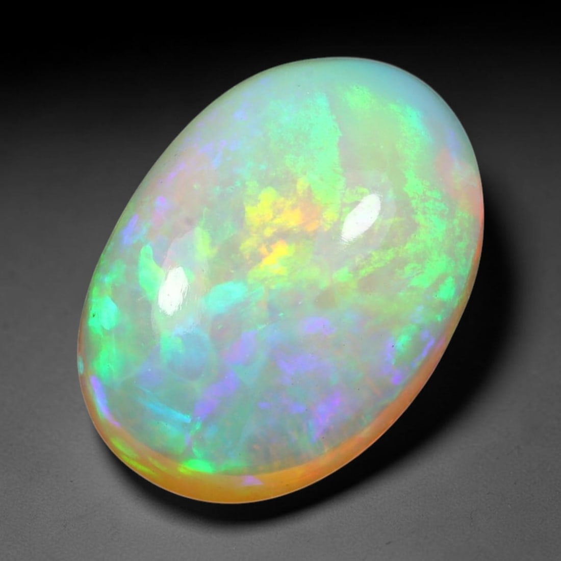 3.66ct Natural Ethiopian Welo Solid Opal Oval Cabochon Loose Gemstone, 31TG: Solid opal cabochon mined from Ethiopia's Welo opal deposits, polished into a smooth elongated oval dome with high reflective gloss. The translucent pale milky base hosts broad shifting play-of-color 