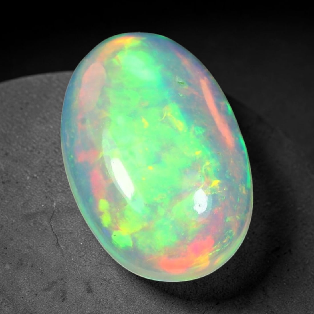 1.61ct Natural Ethiopian Welo Solid Opal Oval Cabochon Loose Gemstone, 60TG: Solid opal cabochon mined from Ethiopia's Welo opal deposits, polished into a smooth elongated oval dome with high reflective gloss. The translucent pale milky base hosts broad shifting play-of-color 