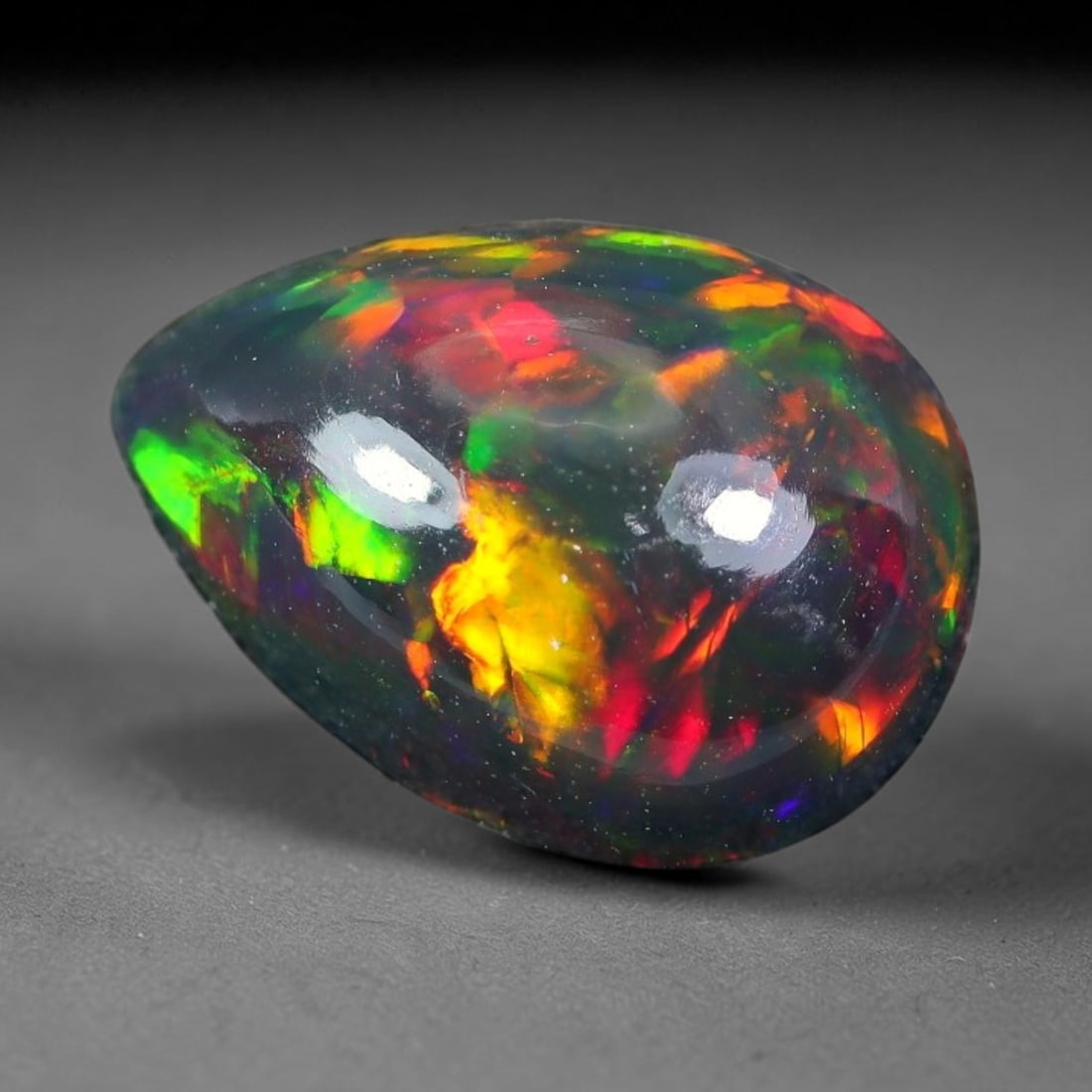 2.00ct Natural Ethiopian Welo Black Smoked Opal Cabochon Loose Gemstone, 79TG: This fully polished Ethiopian Welo opal features a dark smoked base with vivid, sweeping play-of-color shifting across its glossy dome surface, measured at 11.1x8.1x5.2mm. The black smoke treatment de