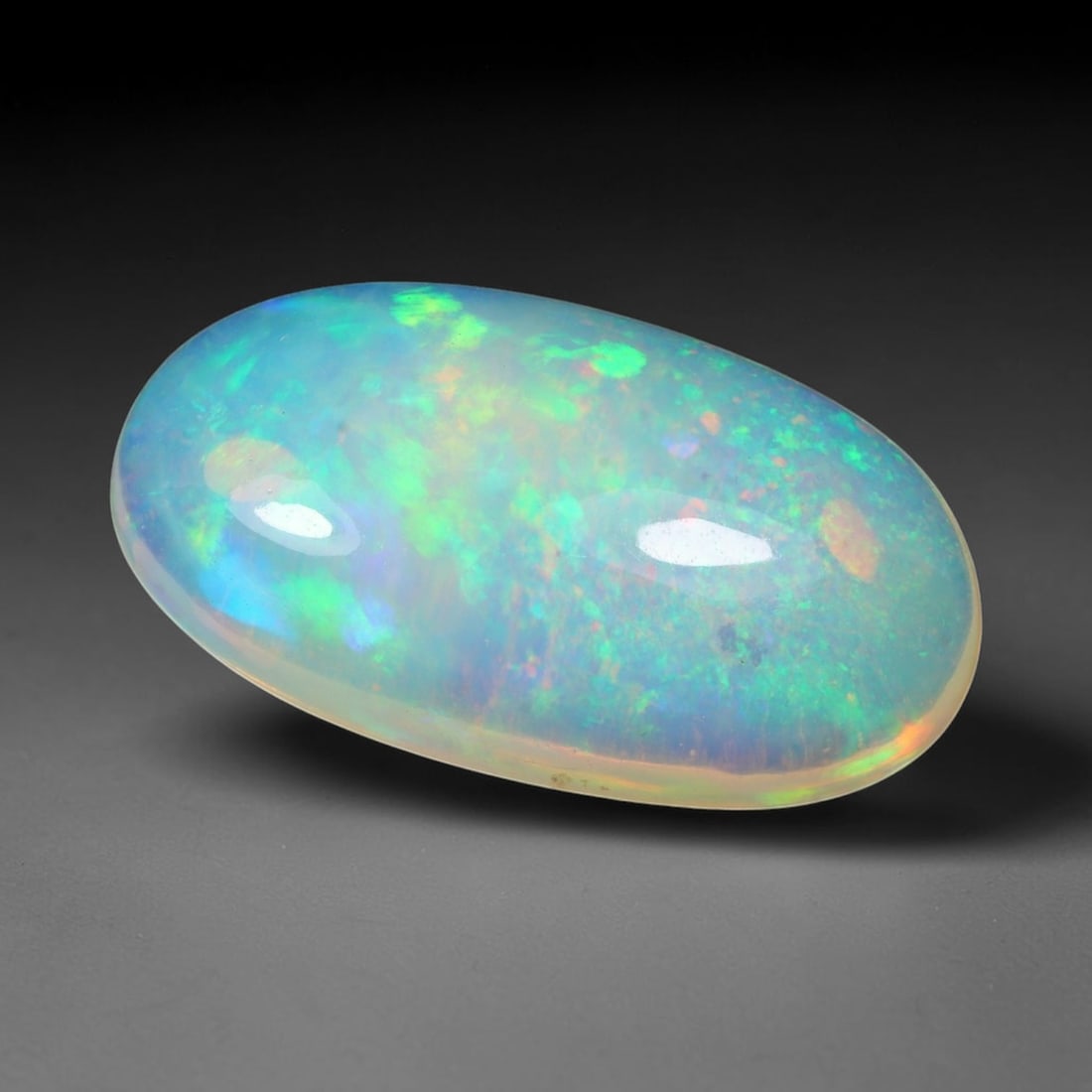 4.48ct Natural Ethiopian Welo Solid Opal Oval Cabochon Loose Gemstone, 26TG: Solid opal cabochon mined from Ethiopia's Welo opal deposits, polished into a smooth elongated oval dome with high reflective gloss. The translucent pale milky base hosts broad shifting play-of-color 