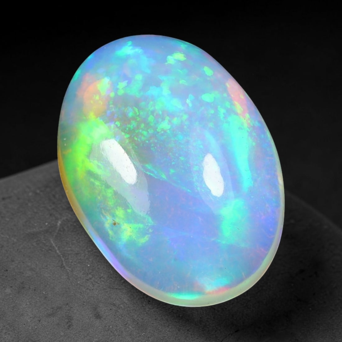 3.88ct Natural Ethiopian Welo Solid Opal Oval Cabochon Loose Gemstone, 28TG: Solid opal cabochon mined from Ethiopia's Welo opal deposits, polished into a smooth elongated oval dome with high reflective gloss. The translucent pale milky base hosts broad shifting play-of-color 