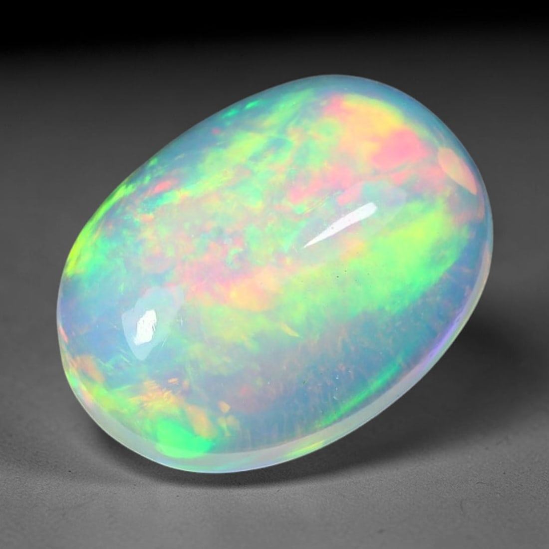 1.81ct Natural Ethiopian Welo Solid Opal Oval Cabochon Loose Gemstone, 46TG: Solid opal cabochon mined from Ethiopia's Welo opal deposits, polished into a smooth elongated oval dome with high reflective gloss. The translucent pale milky base hosts broad shifting play-of-color 