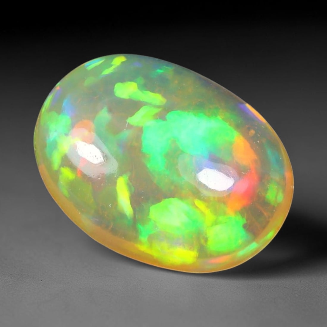 1.88ct Natural Ethiopian Welo Solid Opal Oval Cabochon Loose Gemstone, 63TG: Solid opal cabochon mined from Ethiopia's Welo opal deposits, polished into a smooth elongated oval dome with high reflective gloss. The translucent pale milky base hosts broad shifting play-of-color 