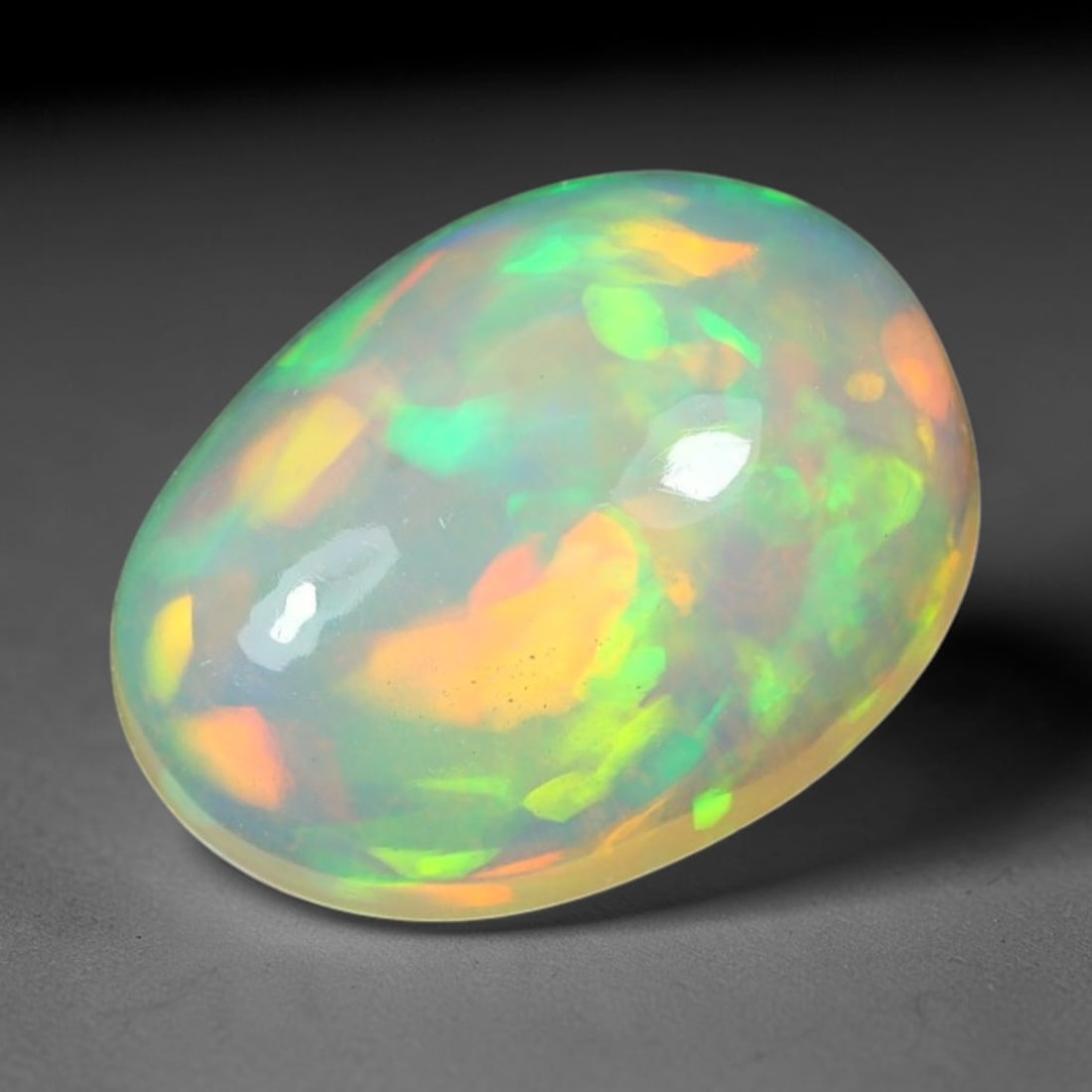 1.71ct Natural Ethiopian Welo Solid Opal Oval Cabochon Loose Gemstone, 45TG: Solid opal cabochon mined from Ethiopia's Welo opal deposits, polished into a smooth elongated oval dome with high reflective gloss. The translucent pale milky base hosts broad shifting play-of-color 