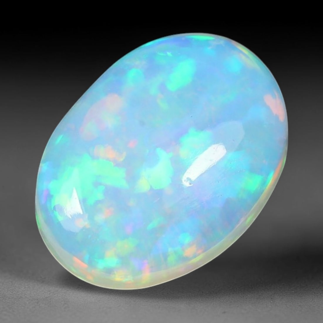 1.80ct Natural Ethiopian Welo Solid Opal Oval Cabochon Loose Gemstone, 58TG: Solid opal cabochon mined from Ethiopia's Welo opal deposits, polished into a smooth elongated oval dome with high reflective gloss. The translucent pale milky base hosts broad shifting play-of-color 