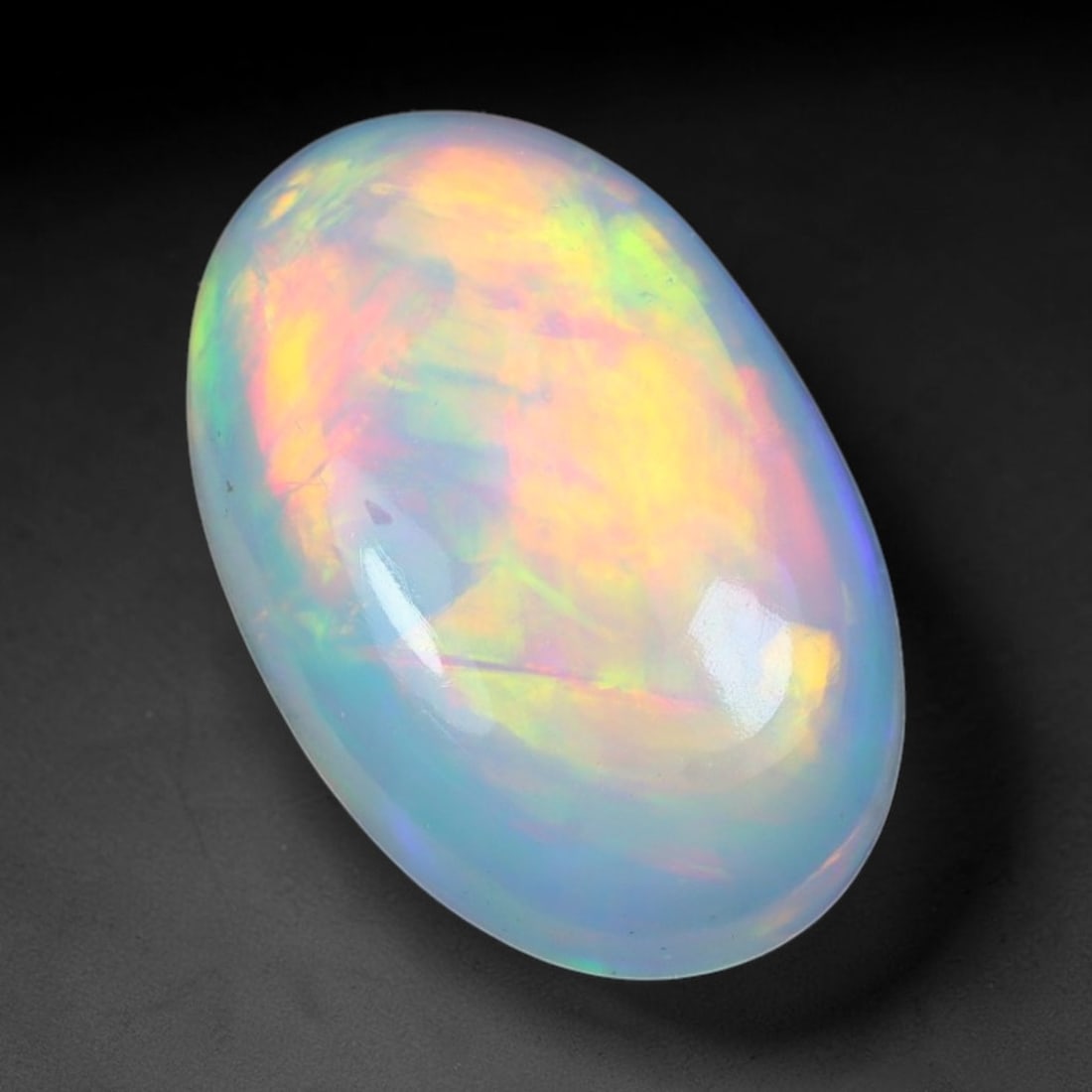 2.07ct Natural Ethiopian Welo Solid Opal Oval Cabochon Loose Gemstone, 44TG: Solid opal cabochon mined from Ethiopia's Welo opal deposits, polished into a smooth elongated oval dome with high reflective gloss. The translucent pale milky base hosts broad shifting play-of-color 