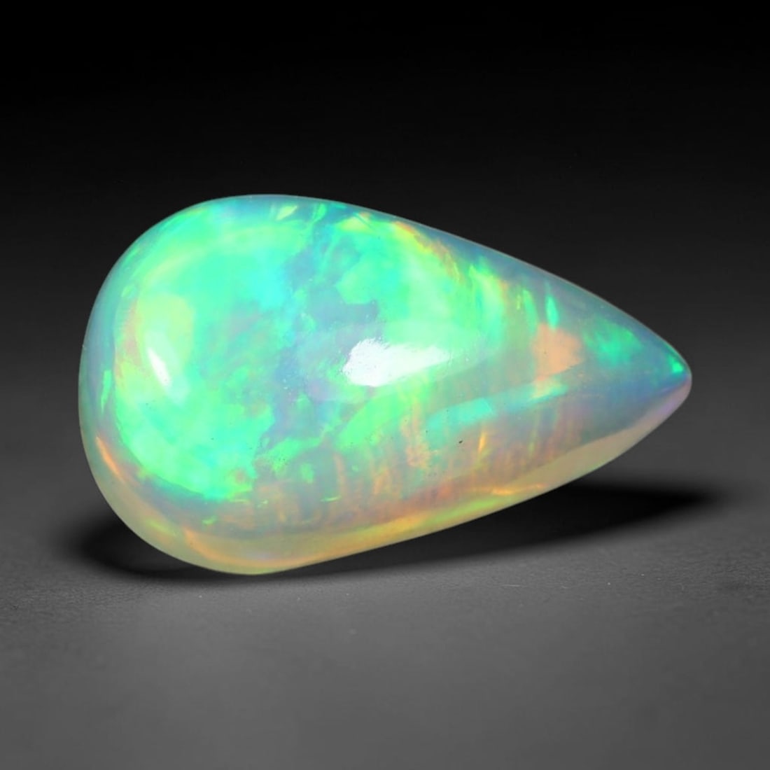 1.95ct Natural Ethiopian Welo Solid Opal Oval Cabochon Loose Gemstone, 56TG: Solid opal cabochon mined from Ethiopia's Welo opal deposits, polished into a smooth elongated oval dome with high reflective gloss. The translucent pale milky base hosts broad shifting play-of-color 